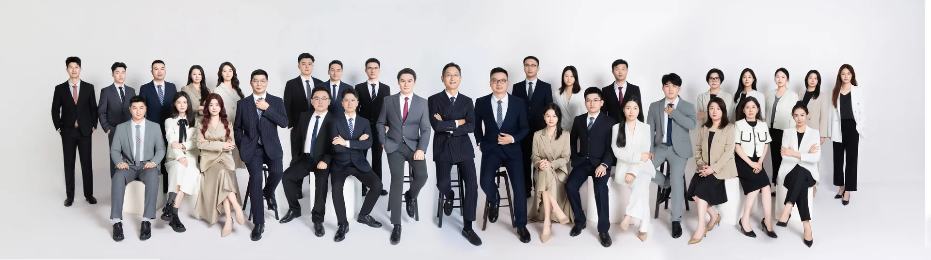 优贝德全体同事的影棚全家福:同事们身着正装,分四排整齐站坐,白色背景