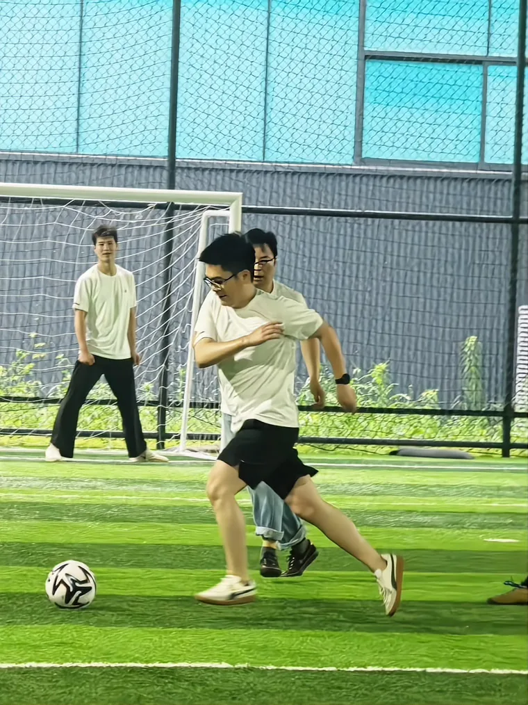 A colleague striking the ball during the match, a teammate following behind